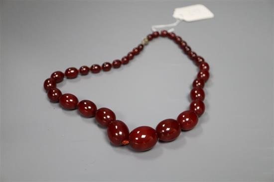 A single strand graduated simulated cherry amber bead necklace, 52cm, gross 63 grams.